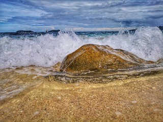 Closeup with the sandy beach splashing water and swash wave in Kota Kinabalu, Tanjung Aru beach....