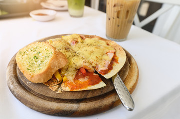 Thin crispy pizza cheese with salmon, ham, bacon on wood tray