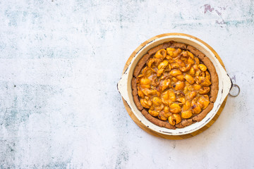Tasty homemade apricot, apples, medlar baked tart, pie or cake with berries on light background...