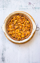 Tasty homemade apricot, apples, medlar baked tart, pie or cake with berries on light background surface. Top above view