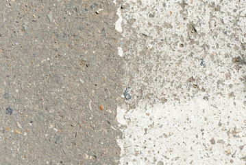 Old asphalt surface with white paint on it close up. Abstract background