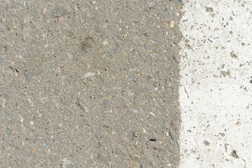 Old asphalt surface with white paint on it close up. Abstract background