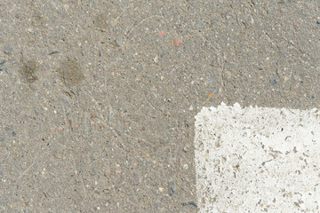 Old asphalt surface with white paint on it close up. Abstract background