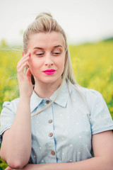 beautiful girl posing for the camera in the rapeseed field