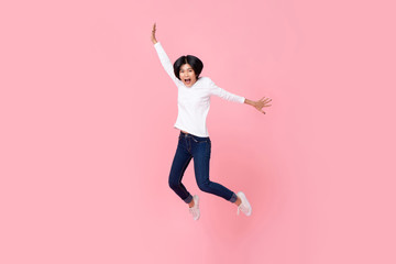 Happy energetic asian woman wearing casual clothes jumping in mid-air