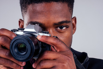 handsome photographer happy young african man Kenya Africa tourist holding photo camera trip around the world white background studio