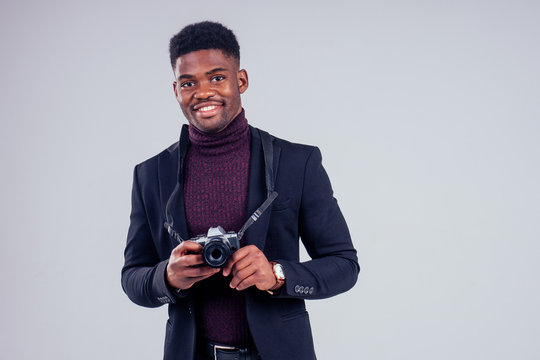 handsome photographer happy young african man Kenya Africa tourist holding photo camera trip around the world white background studio
