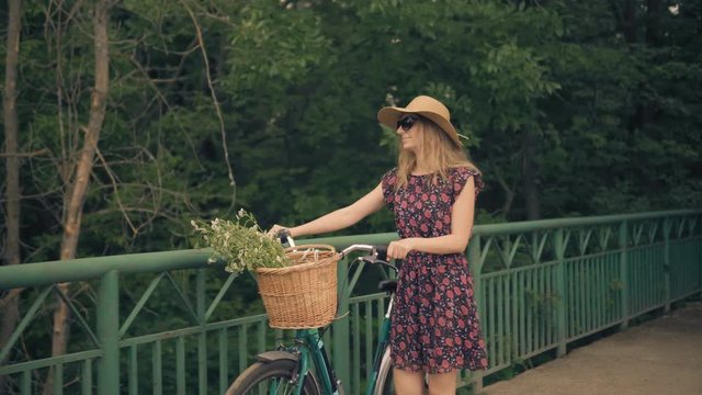Cyclist Woman Cycling On Bicycle.Girl Cycling On Bike.Cyclist Beautiful Woman Wearing Dress Rides Bicycle.Happy Woman In Hat Riding On Bicycle.Pretty Girl On Bicycle.Woman With Blonde Hair Cycling