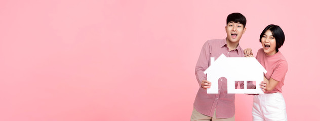 Asian couple holding paper home on pink banner background - Powered by Adobe