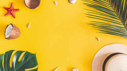 Summer composition. Tropical palm leaves, hat, coconut on yellow background. Summer concept. Flat lay, top view, copy space