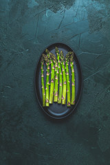 Green asparagus in black metal pan