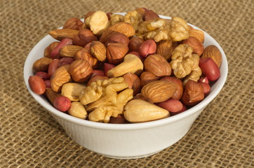 Different nuts in a bowl on burlap