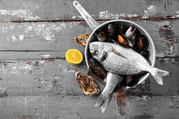 Pot with fresh seafood on wooden table