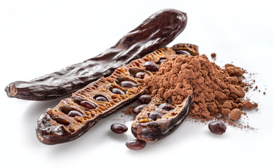 Obraz premium Carob pods and carob powder on the white background.