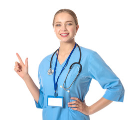Young medical assistant pointing at something on white background