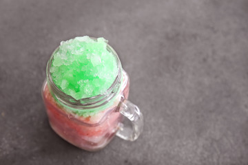 Mason jar with tasty shaved ice on grey background