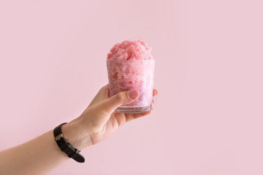 Female Hand Holding Glass Of Tasty Shaved Ice On Color Background