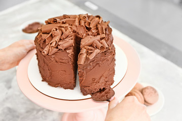 Woman with tasty chocolate cake at table, closeup
