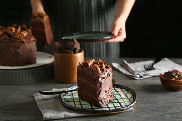 Plate with piece of tasty chocolate cake on table