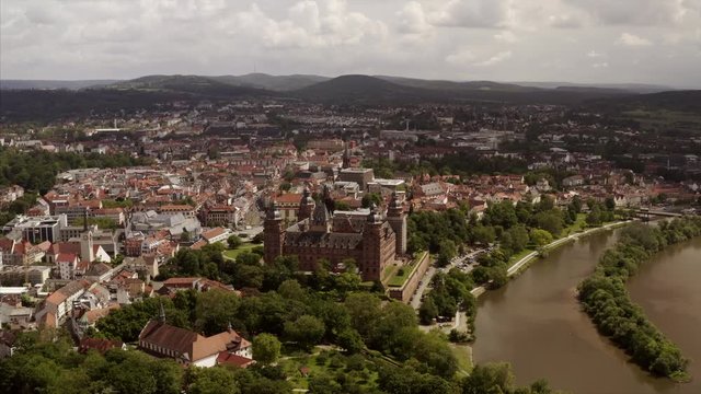 The river Main with the cityscape of Aschaffenburg, Germany, in a smooth aerial shot. The drone is showing the whole city from above.
