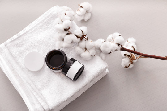 Shampoo, towel and cotton branch on table