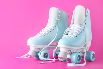 Vintage roller skates on color background