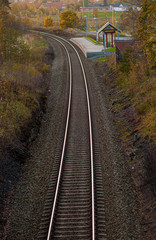 Fototapeta na wymiar Curved railway tracks with at small station.