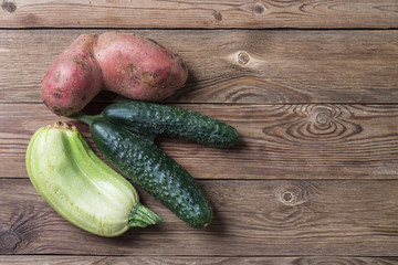 Trendy ugly organic natural squash, cucumber and potato on natural wooden table. Copy space.