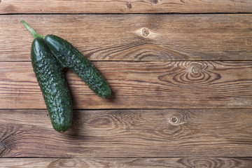 Trendy ugly organic natural cucumber on natural wooden table. Copy space.