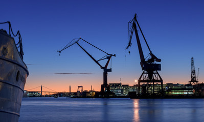 cranes of and old wharf in a beautiful sunset.