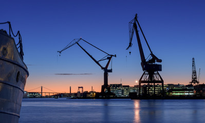 Fototapeta na wymiar cranes of and old wharf in a beautiful sunset.