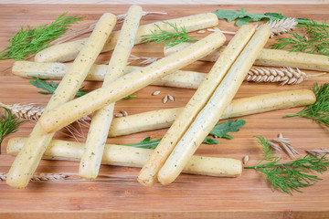 Breadsticks with Italian herbs among fresh greens and cereals ears