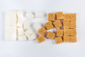 White and brown sugar cubes on a light surface