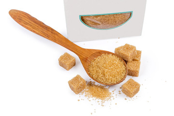 Brown sugar in wooden spoon and beside, brown sugar cubes