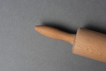 Woden rolling pin on grey background.