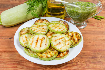 Grilled chopped by circles vegetable marrows against some ingredients, seasonings