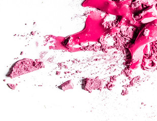 Crushed eyeshadows, lipstick and powder isolated on white background