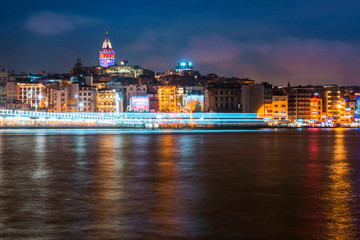 Obraz premium Night view of Istanbul cityscape Galata Tower with floating tourist boats in Bosphorus ,Istanbul Turkey