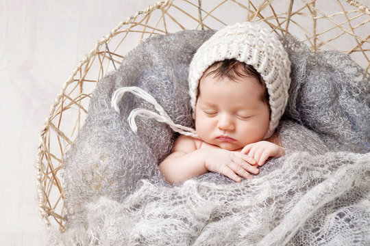 Beautiful little newborn baby 2 weeks sleeping in a basket