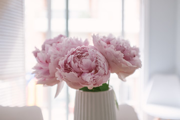 Pink peony flowers bouquet in bloom on an indoor decoration vase