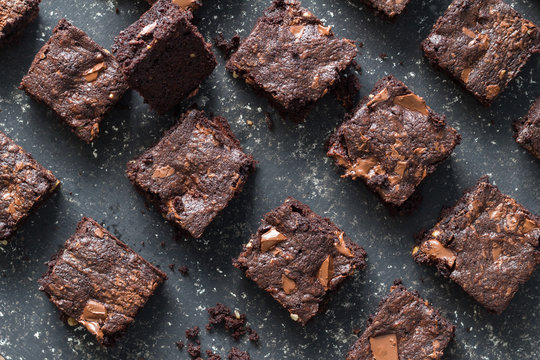 Chocolate brownie squares on black mottled background - baked chocolate brownies