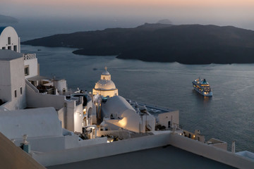 Fototapeta na wymiar Romantic Santorini island during sunset, Greece. Picturesque view of the city of Santorini. White buildings, sea, mountains. Romantic vacation by the sea
