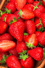 Juicy washed strawberries in wooden bowl on kitchen table.