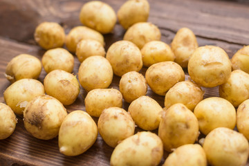 Closeup of a pile of new potatoes on a rustic wooden board.