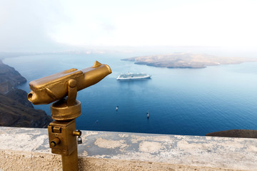 Touristic telescope look at the sea from town in Santorini island. Summer Holidays in Greece.
