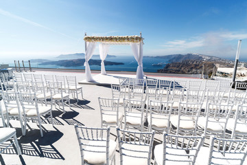 Obraz premium Beautifully arranged place for a wedding ceremony on the Greek coast. Romantic vacation by the sea
