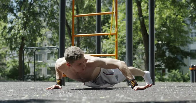 Workout, man sportsmen performs pushups archer, street training and physical activity, 4k slow motion.