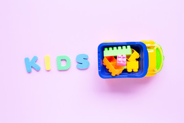 Colorful Kids toys with alphabet "KIDS" on pink background.