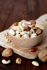 Dried fruits in a wooden bowl on wooden background. Top view with copy space.