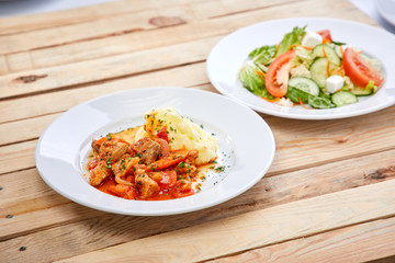chicken with mashed potatoes and salad on the wooden background